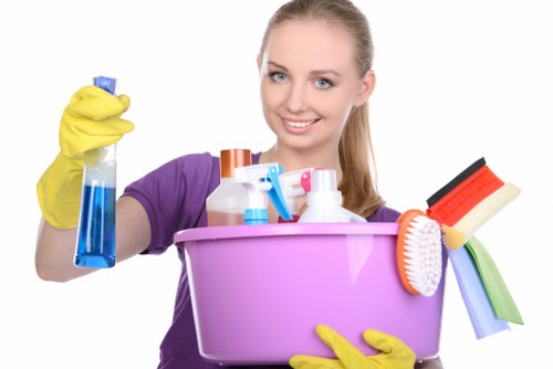 Cleaner working in a compact Bow apartment kitchen during move-out cleaning